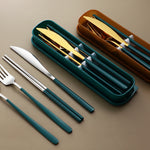 Set of silverware with green handles on a beige surface, including a knife, fork, and spoon.