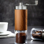 Wooden coffee grinder with ground coffee and coffee beans on a dark background