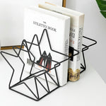 Black geometric bookend holding two books on a white surface